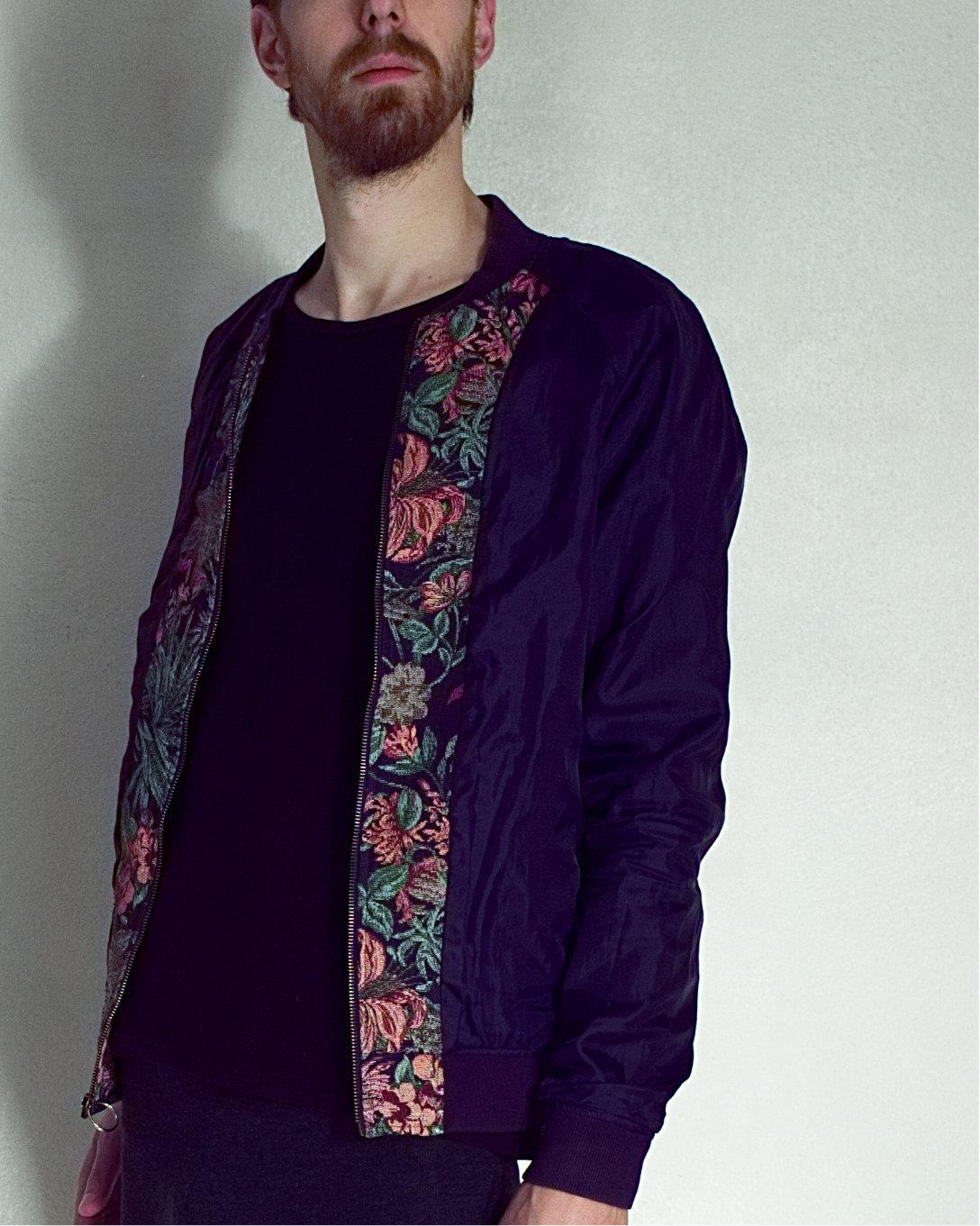 Model wears blue and floral jacket, their eyes are outside the frame hidden