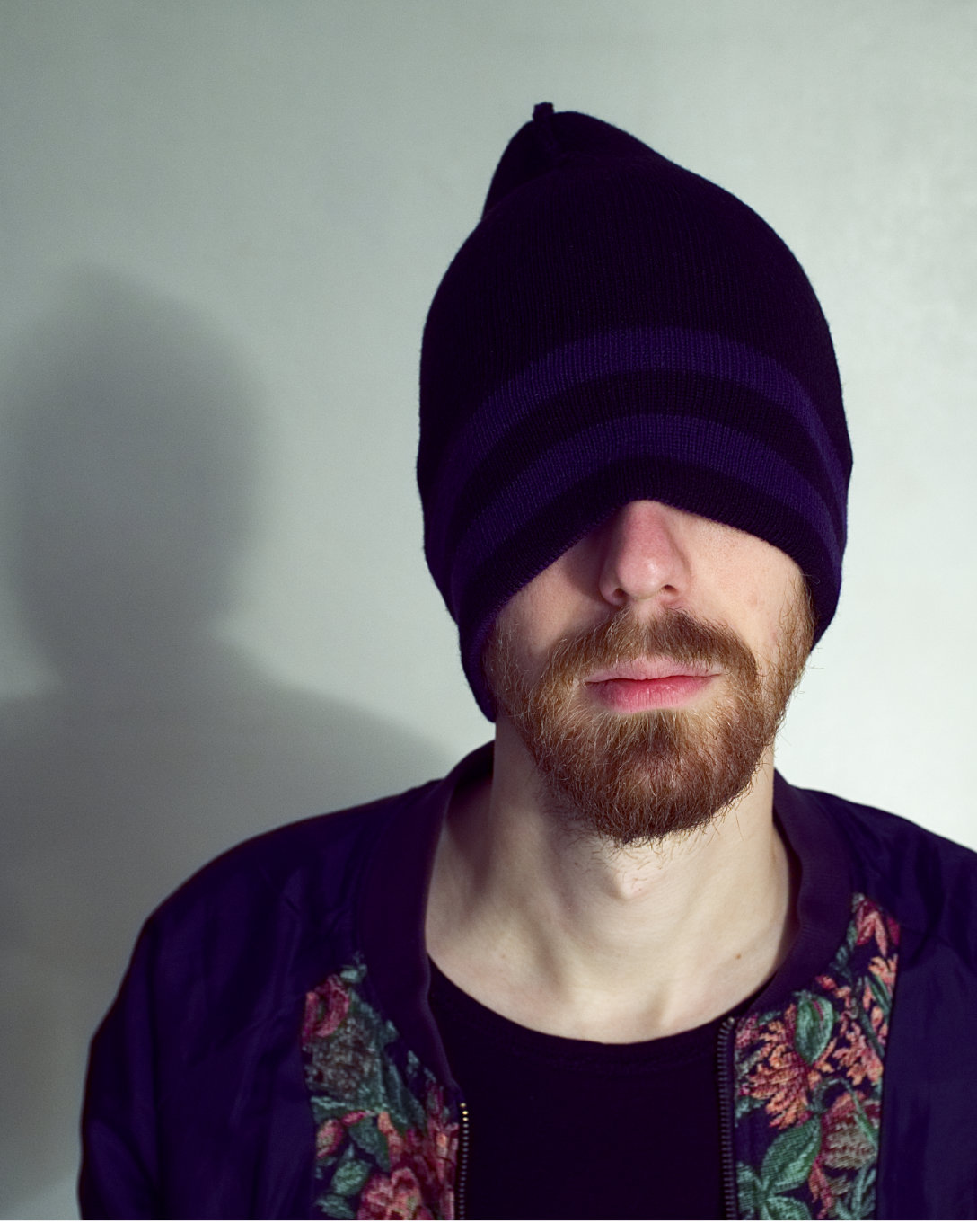 Model wears a knit cap lowered down to cover their eyes