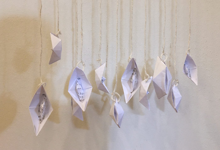 Paper boats hanging on wall